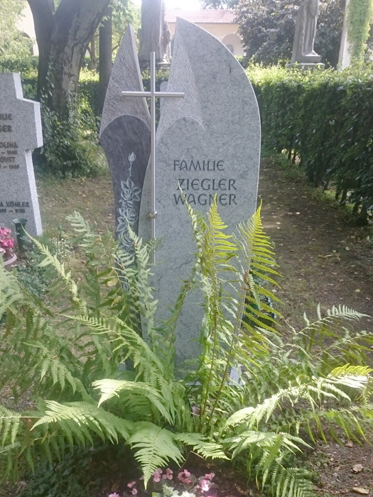 Stehendes Grabmal in München mit Pflanze davor